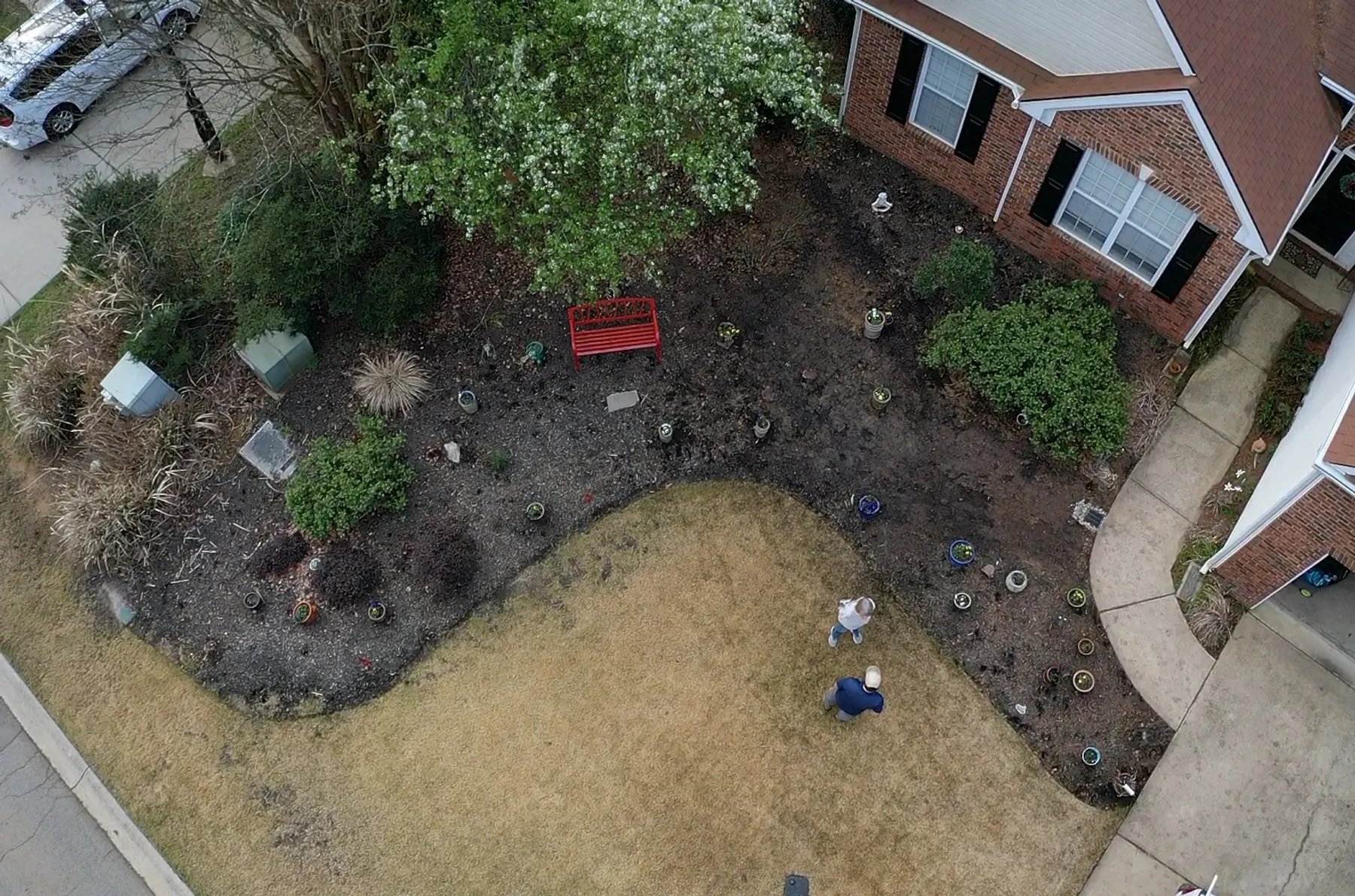 Aerial view of a freshly prepared landscape bed beside a brick home