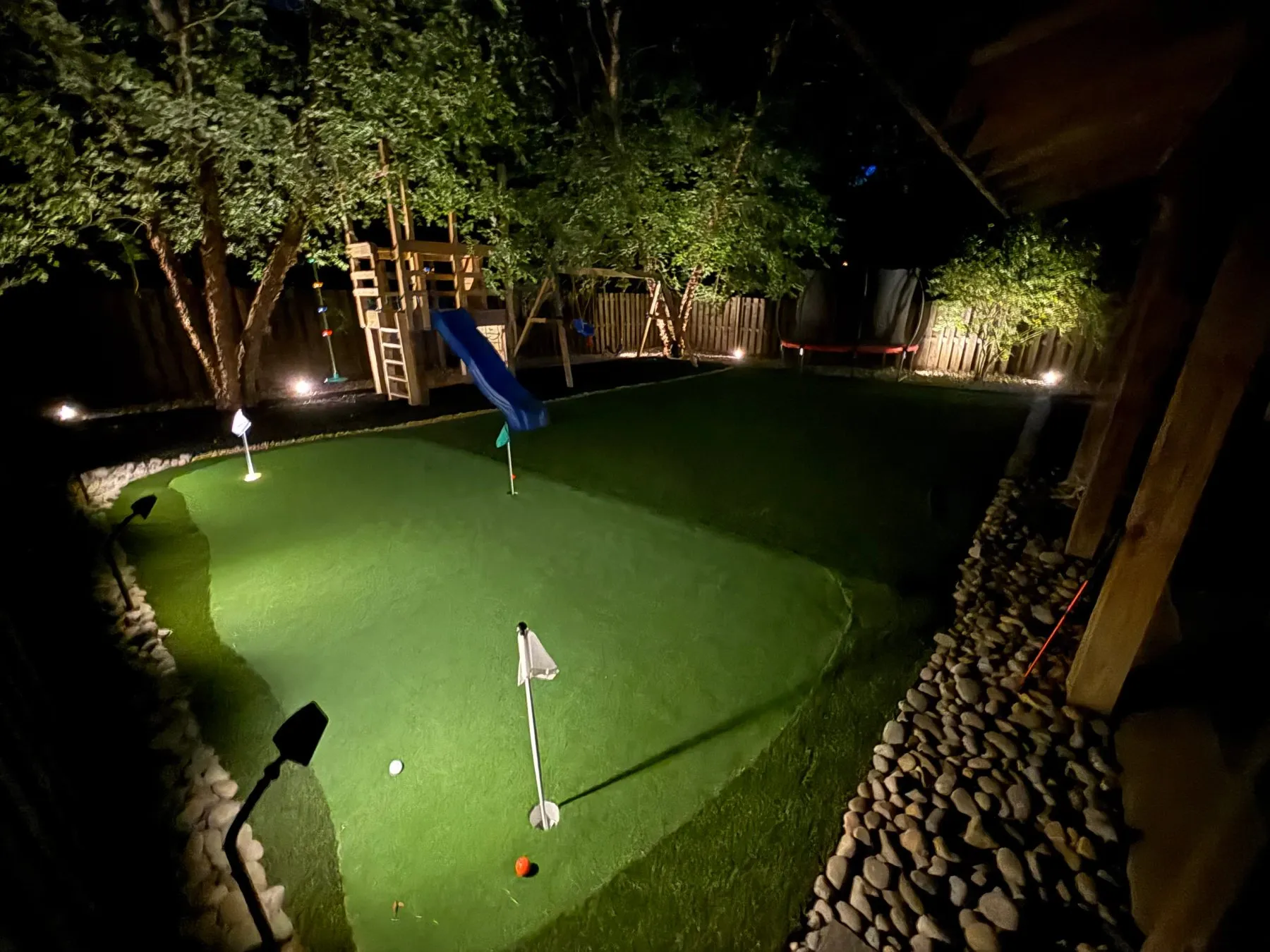 Backyard putting green lit at night